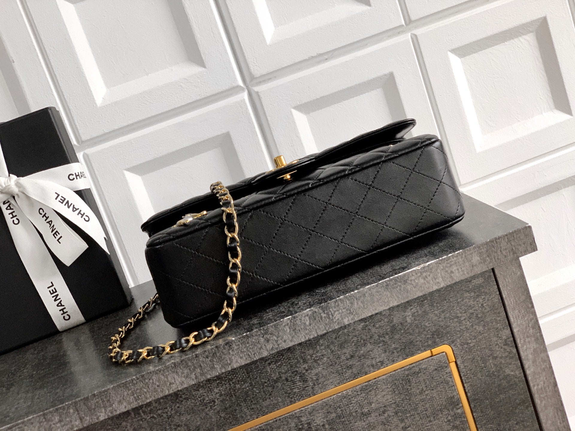 Black Chanel quilted shoulder bag with gold chain strap and flap top
