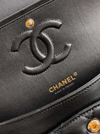 Close-up of Chanel black leather bag with embossed CC logo and gold hardware