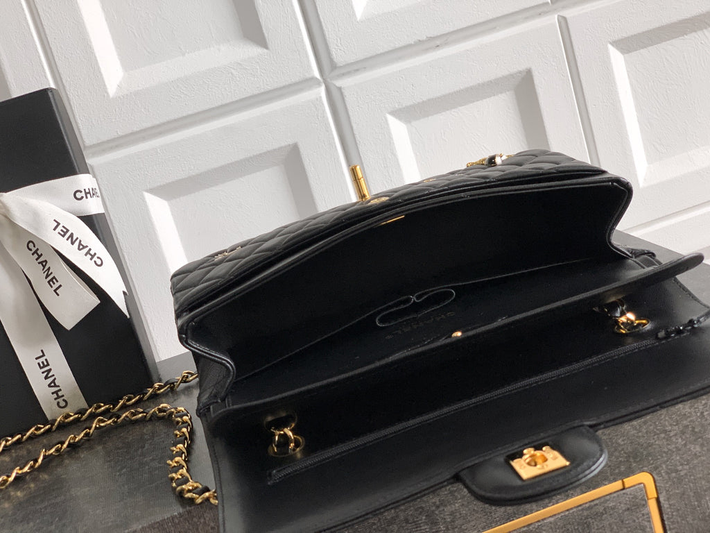 Black Chanel flap shoulder bag with gold chain strap and turn-lock clasp
