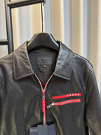 Prada black leather jacket with spread collar, red zip trim, and logo stripe