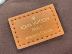 Tan leather Louis Vuitton bag label with gold logo, Paris text, and stitched edges