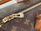 Monogram handbag zipper with gold-tone pull and hardware on dark canvas