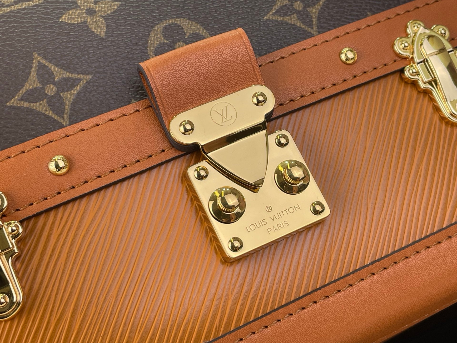 Tan leather strap detail with gold-tone front clasp and Louis Vuitton engraved plate