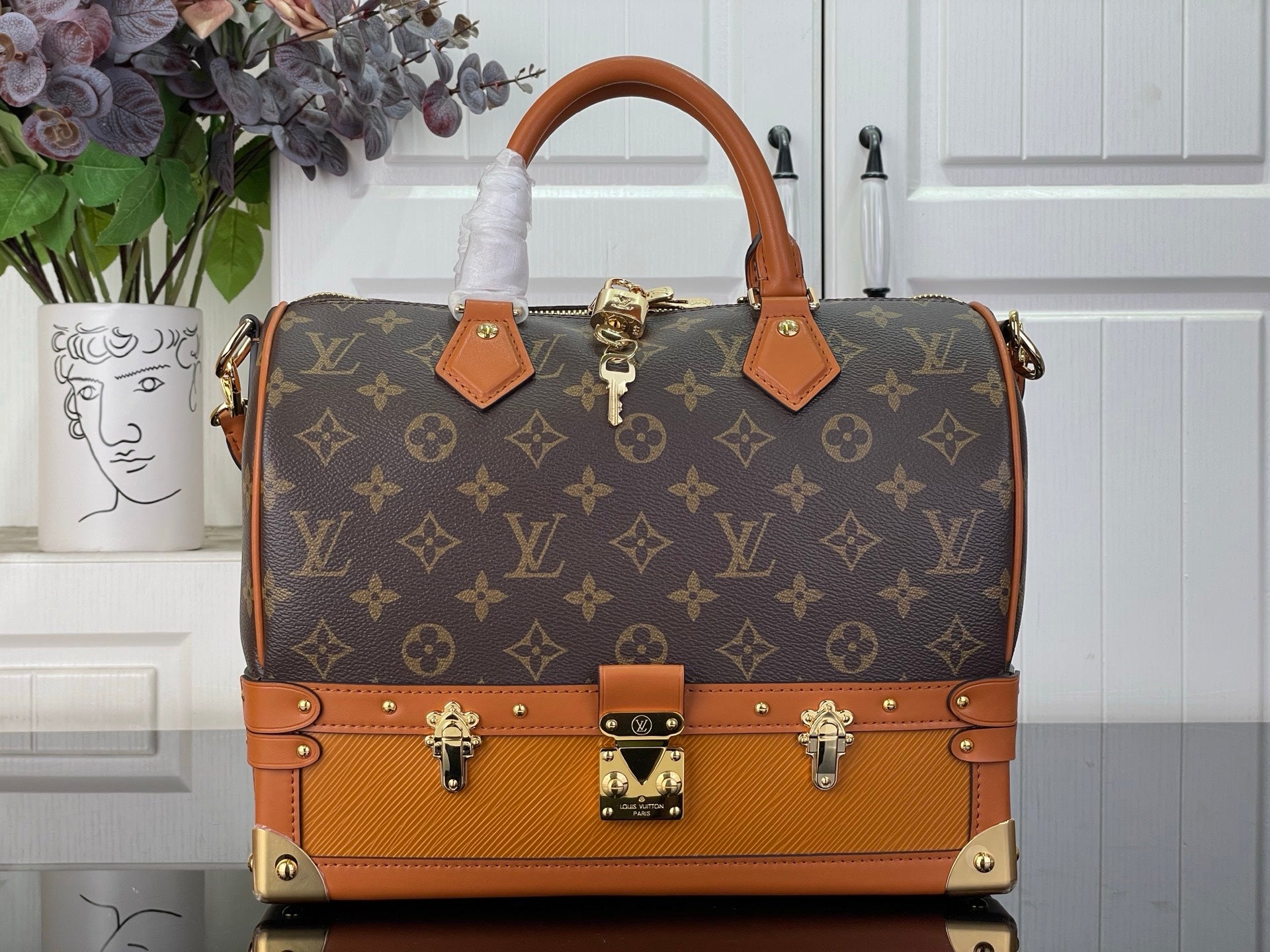 Louis Vuitton monogram handbag with tan leather trim and gold-tone front hardware