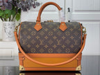 Monogram handbag with tan leather handles, front clasp hardware, and gold-tone accents