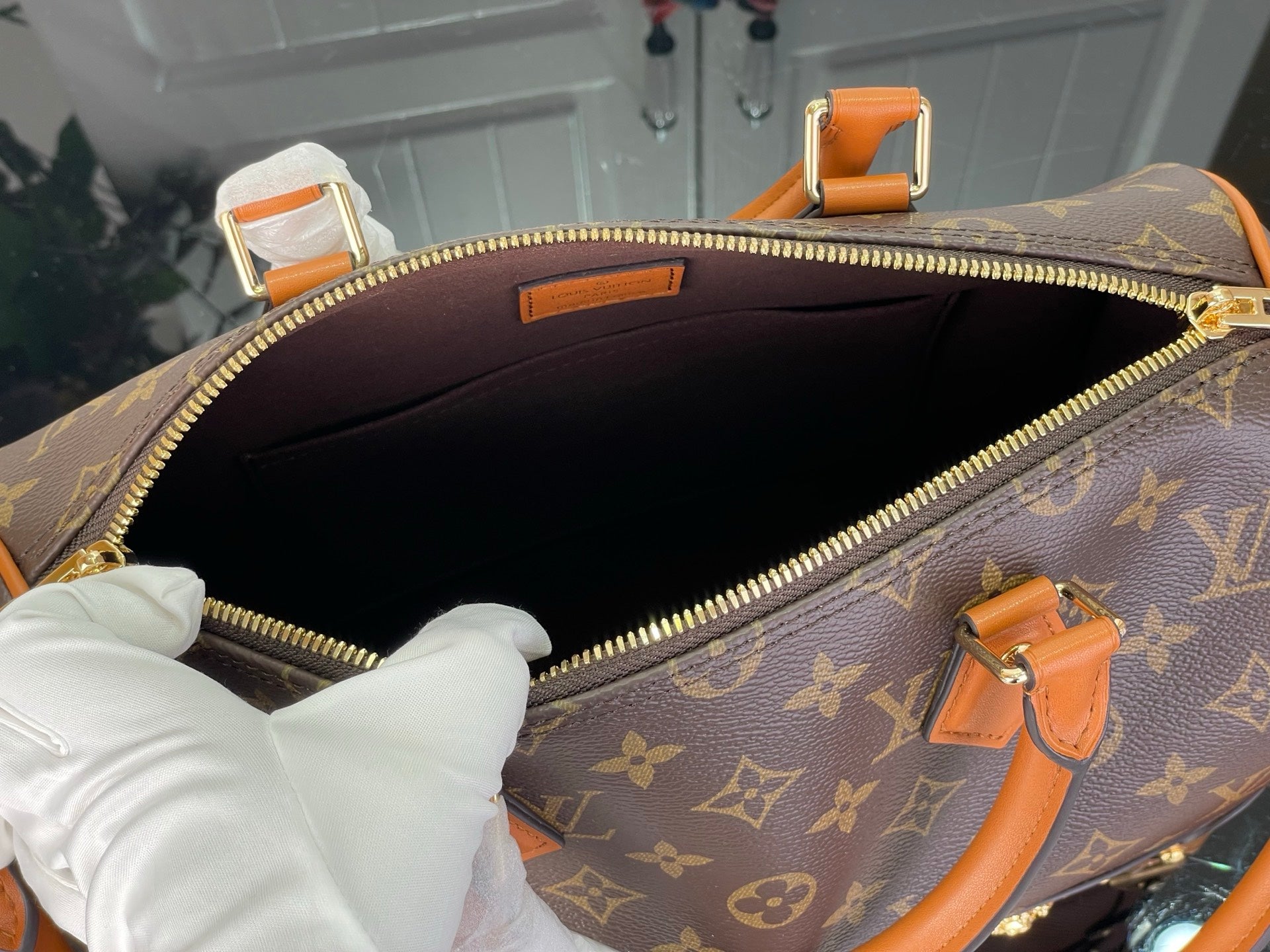 Monogram handbag interior view with dark lining and gold-tone zipper at top opening