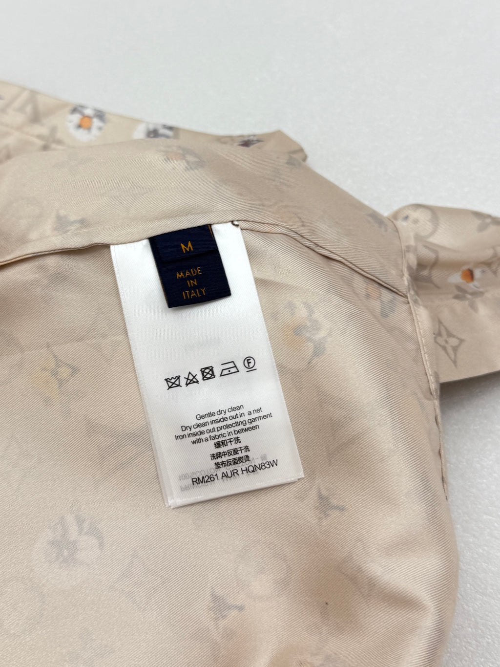 Beige short-sleeve shirt with white care label on inner yoke