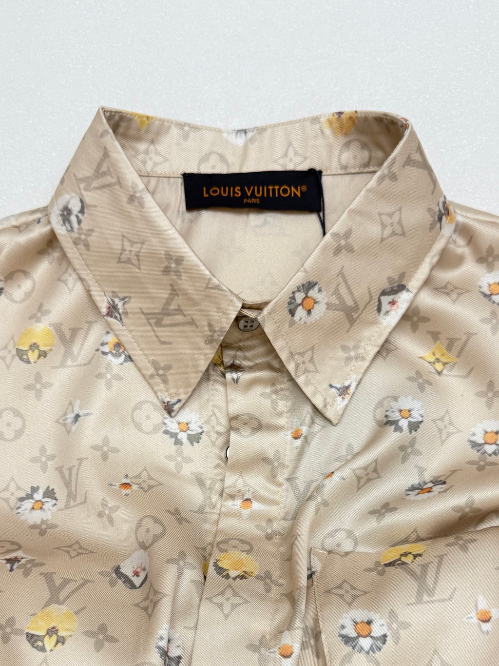 Beige button-up shirt with pointed collar and floral monogram pattern