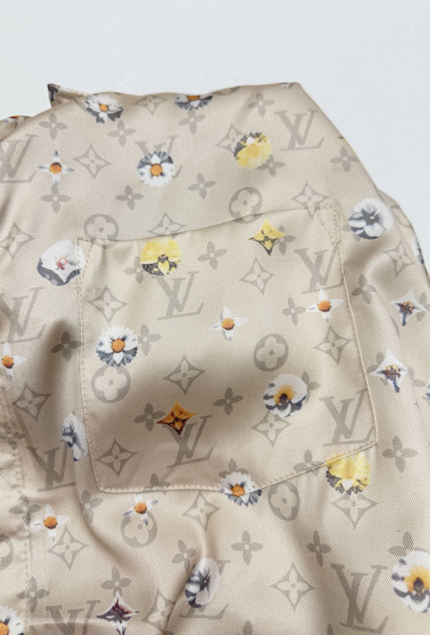Beige short-sleeve shirt fabric with colorful floral monogram pattern