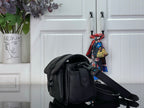 Louis Vuitton black crossbody bag viewed from side with clasp and strap hardware