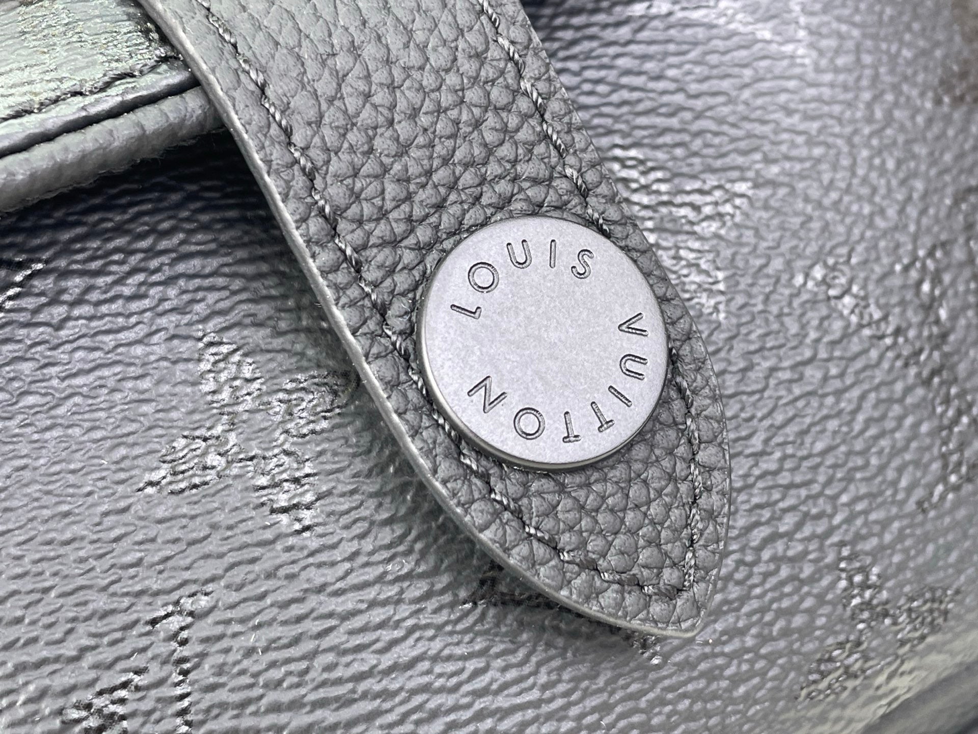 Louis Vuitton leather patch tab with embossed “Louis Vuitton Paris” on black bag
