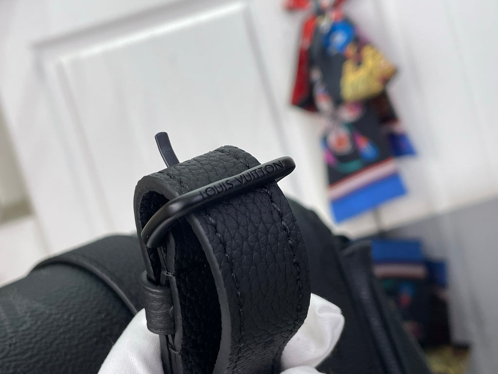 Louis Vuitton black bag close-up of rolled strap and top edge with stitching