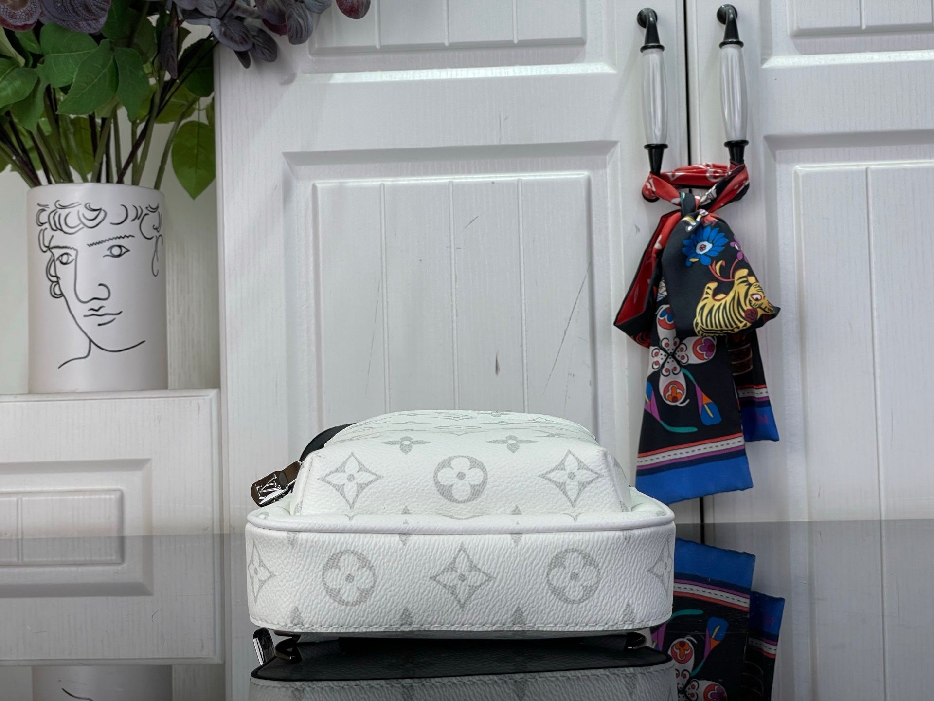 White Louis Vuitton monogram crossbody bag with curved top and visible zipper track