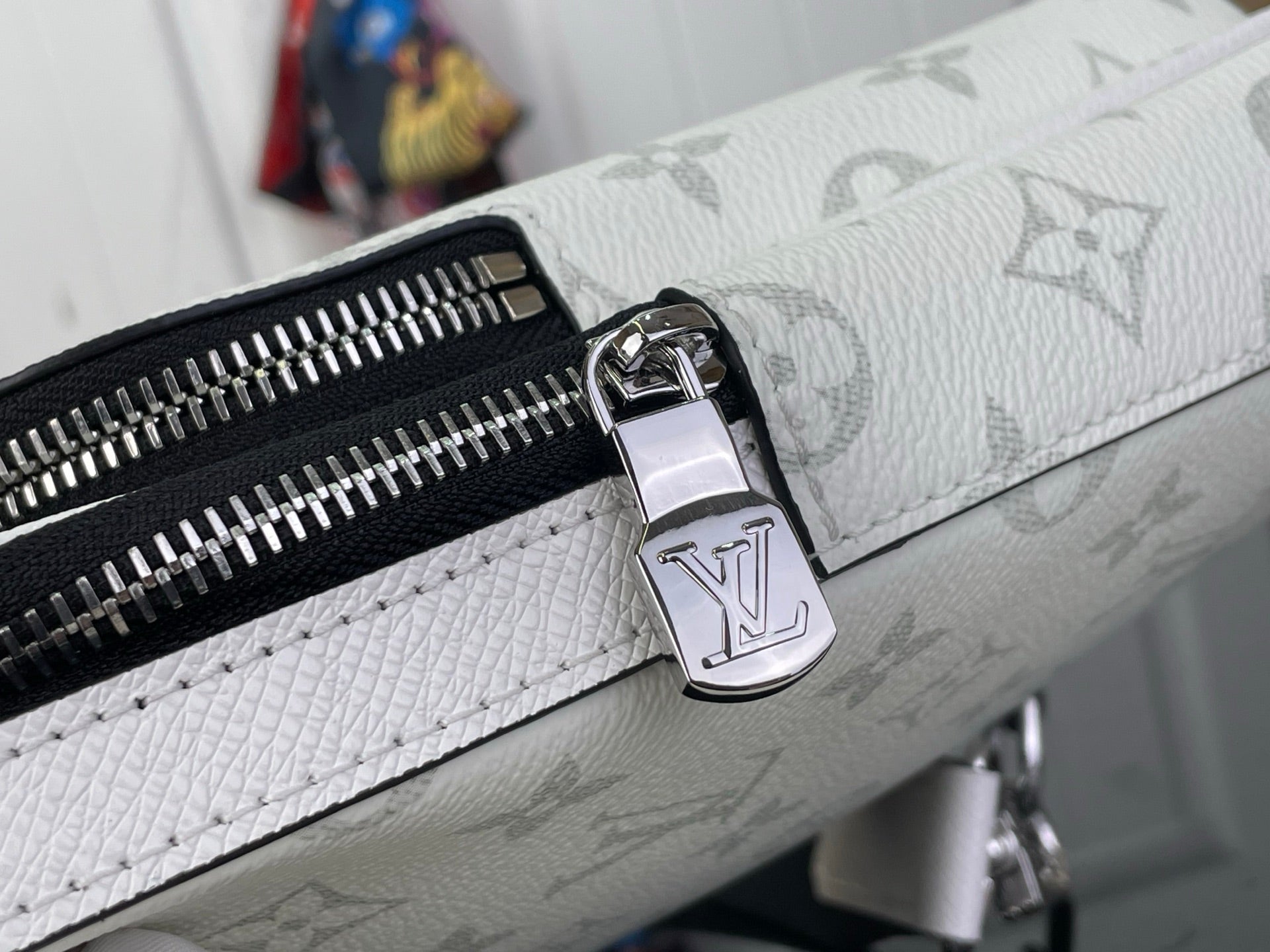White Louis Vuitton monogram bag zipper with metal logo pull