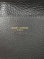 YSL leather mini tote bag close-up, black pebbled texture with branding stamp.