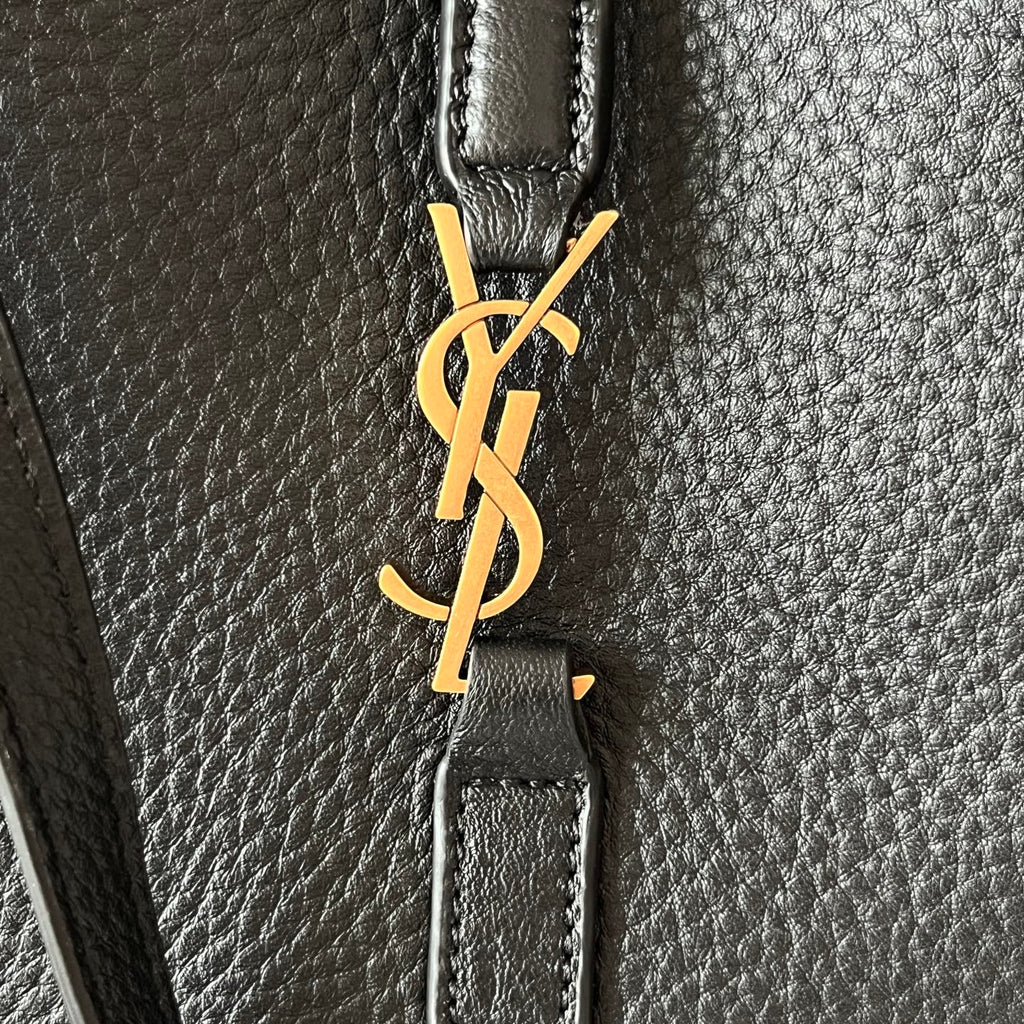 YSL logo clasp on black leather strap, gold-tone hardware detail.