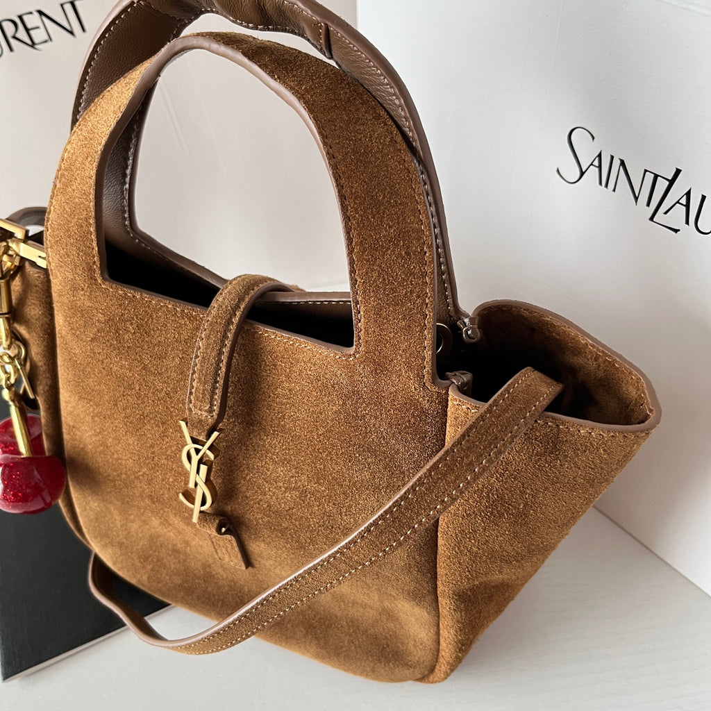 YSL tan suede mini tote front close-up with YSL logo charm on the pocket