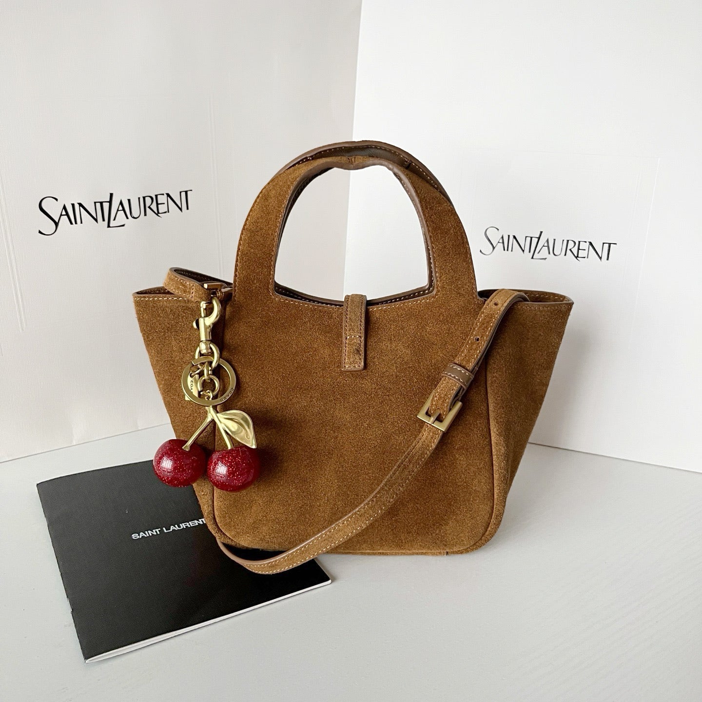 YSL tan suede mini tote with top handles, shoulder strap, and gold hardware charm