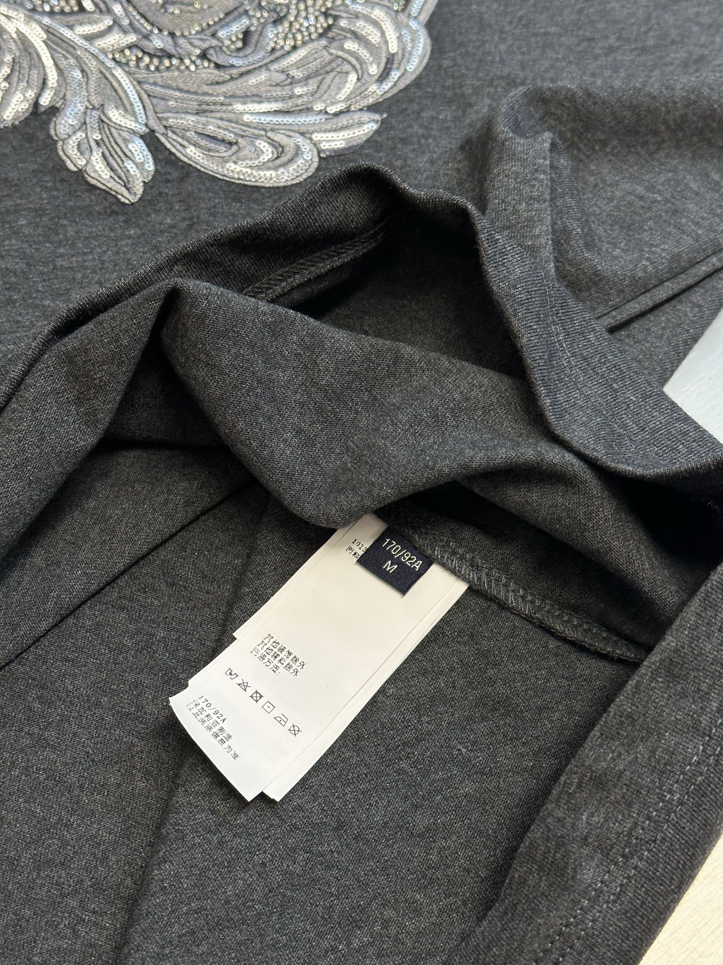 Versace T-shirt inside neck and care labels on dark heather gray fabric