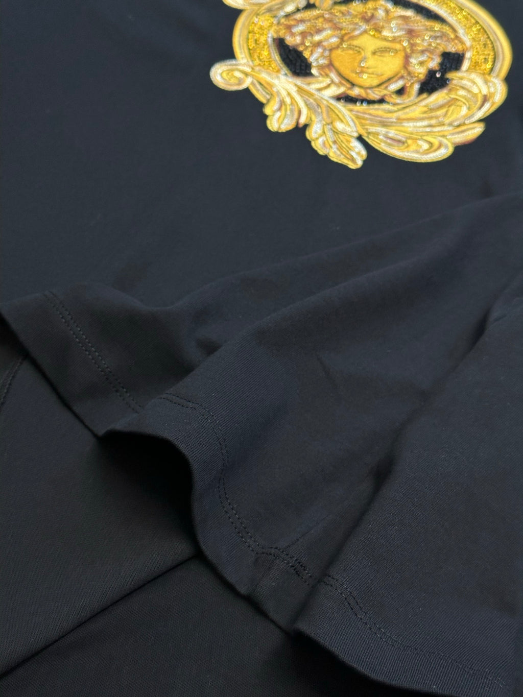 Versace black T-shirt with gold Medusa print and draped sleeve detail