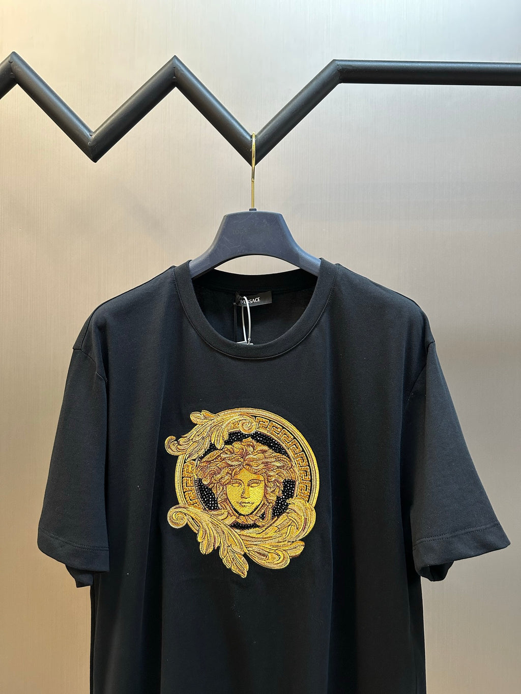 Versace black T-shirt front view with gold Medusa crest on chest