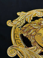 Versace black T-shirt close-up of gold Medusa profile design