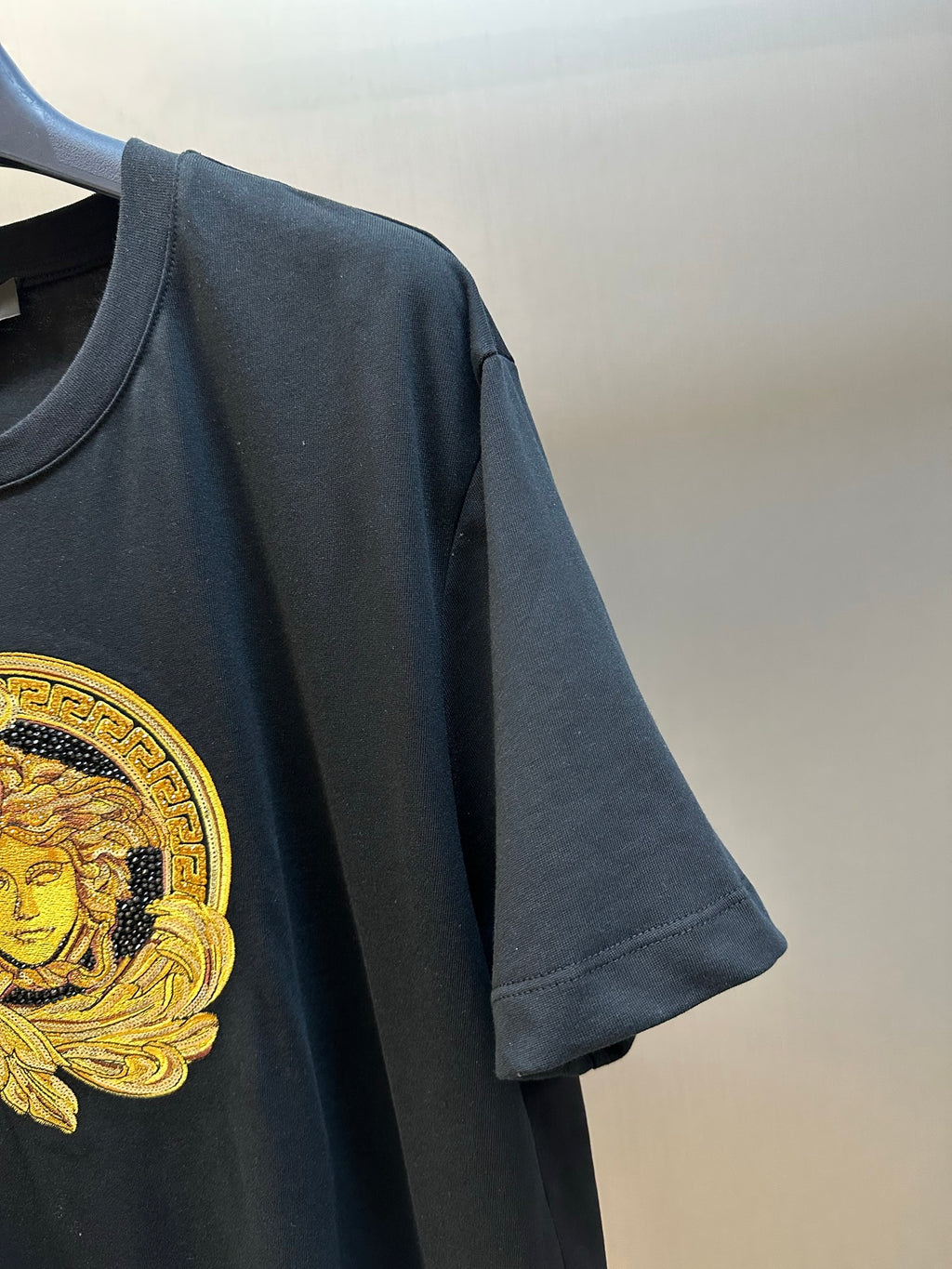 Versace black T-shirt sleeve with gold Medusa crest detail