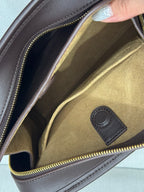 Dark brown leather bag interior opening with gold lining and zip edge