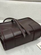 Dark brown leather tote with top handles and stitched panel seams