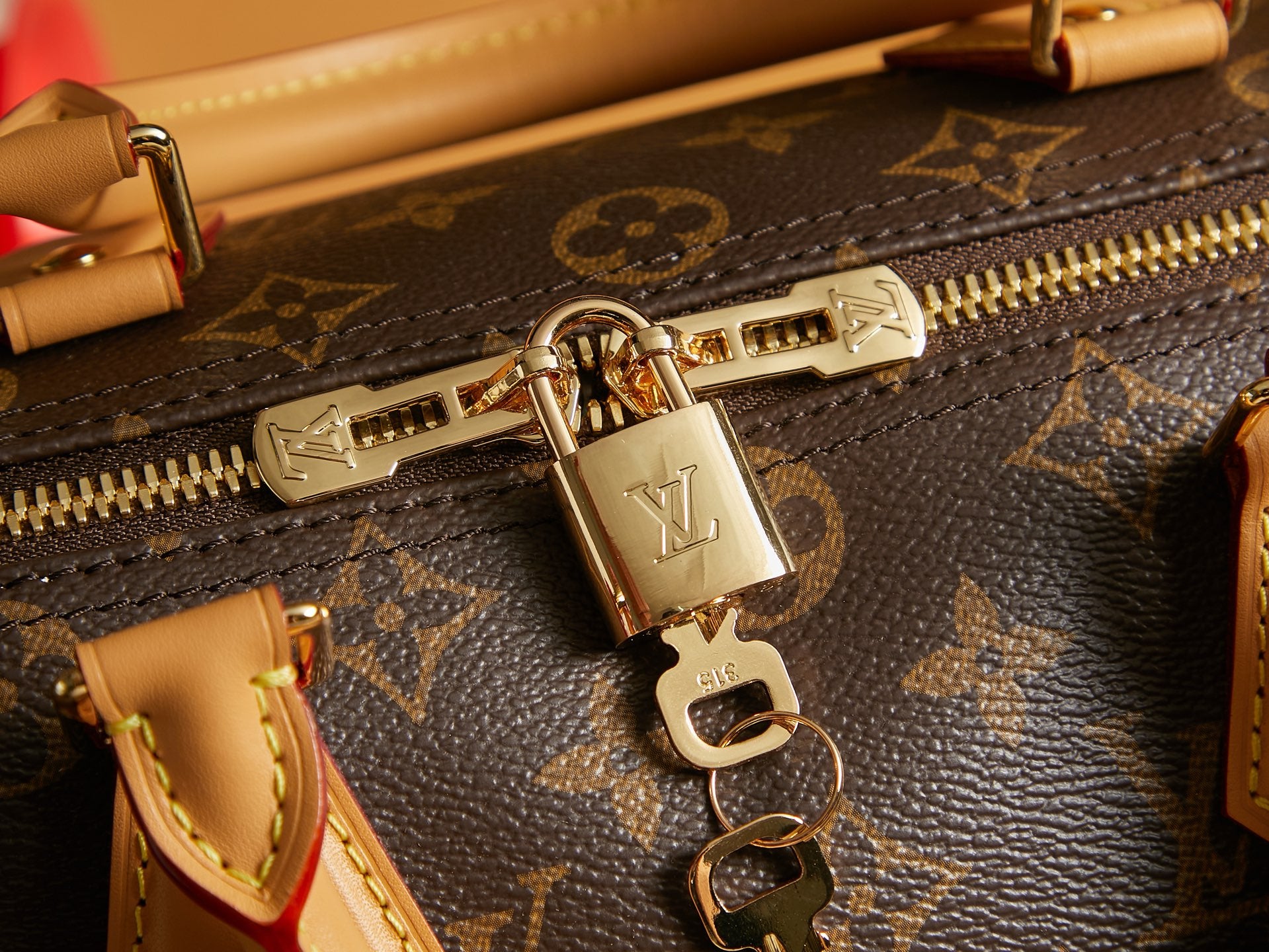 Louis Vuitton monogram bag zipper pull with metal lock and gold ring