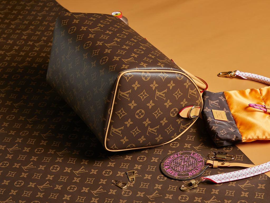 Louis Vuitton monogram shoulder bag with gold-trimmed side and wristlet strap