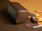 Louis Vuitton monogram shoulder bag with gold-trimmed side and wristlet strap