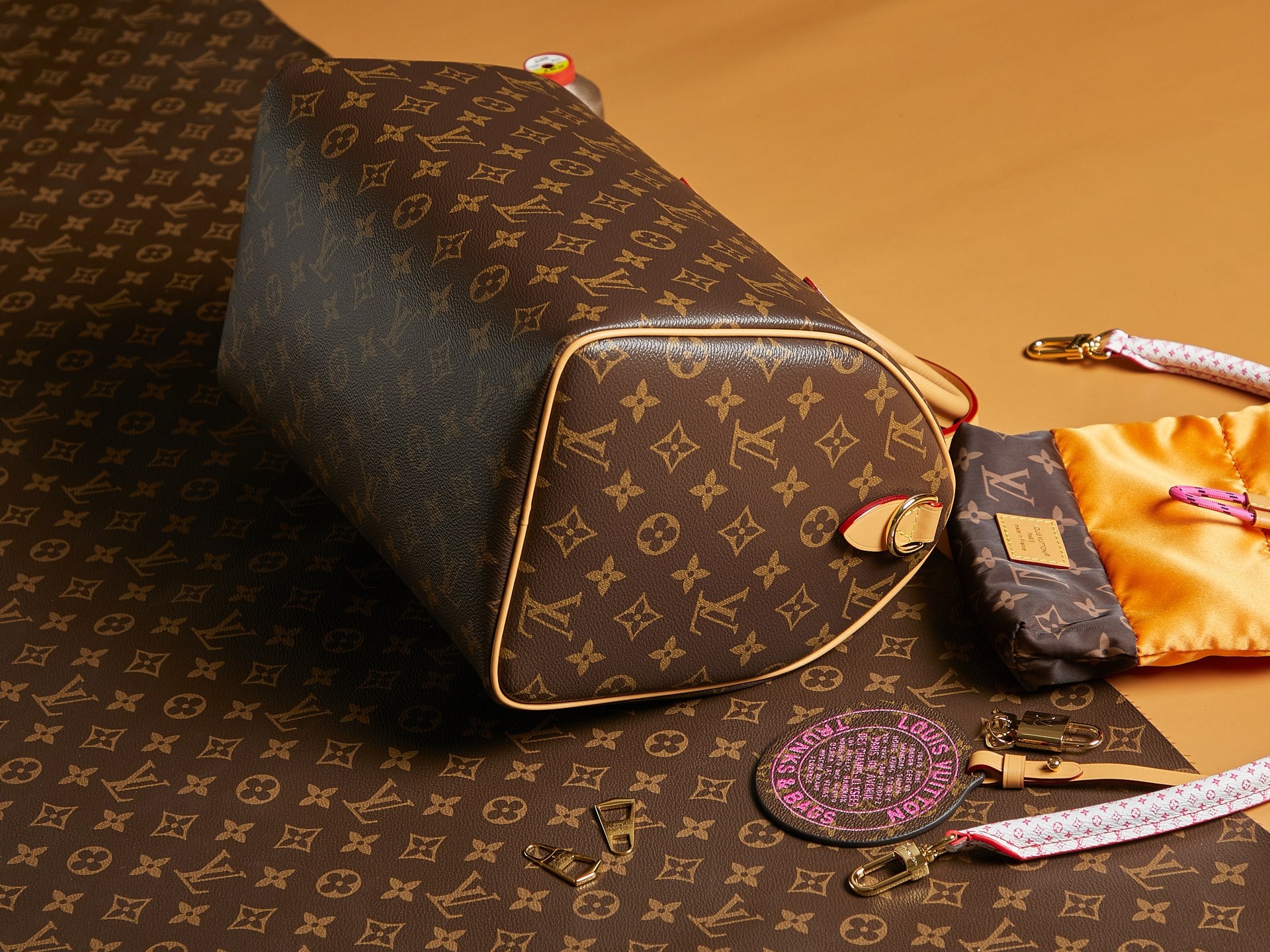 Louis Vuitton monogram shoulder bag with gold-trimmed side and wristlet strap