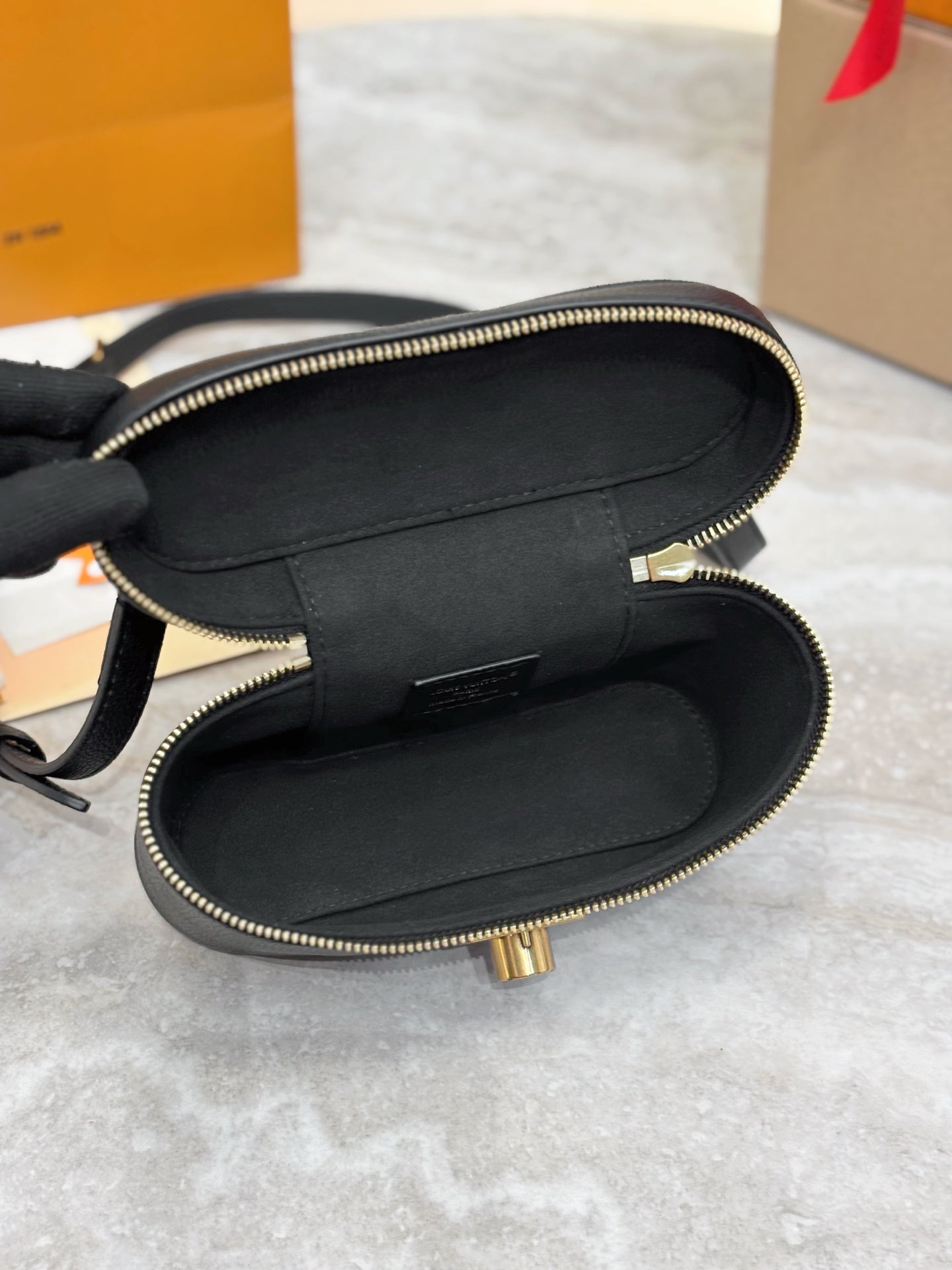 Louis Vuitton bag open interior with dark lining and gold zipper hardware