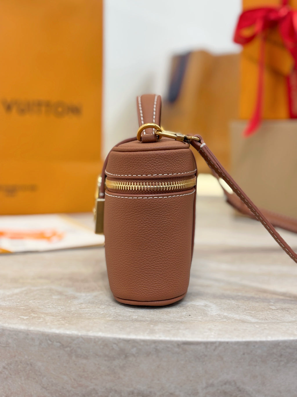 Louis Vuitton brown leather top-handle bag with side zipper and crossbody strap attachment