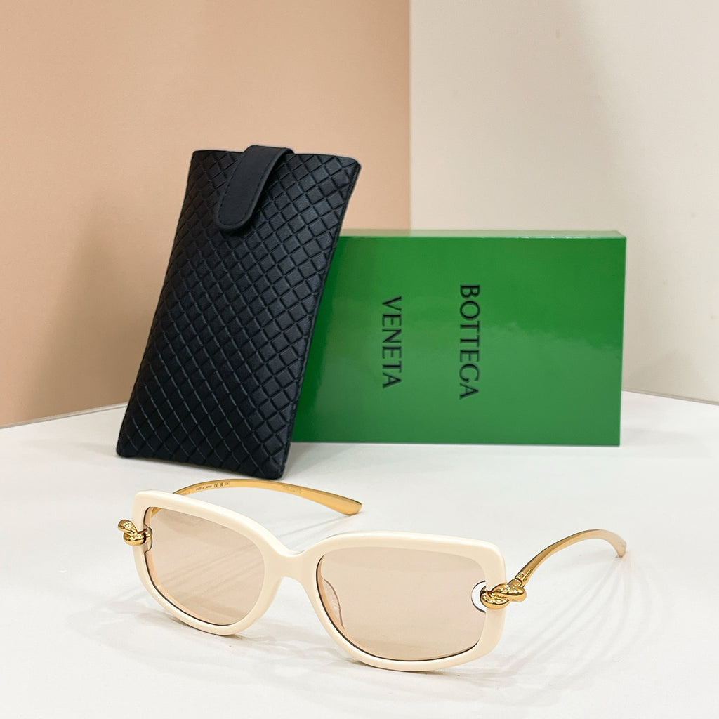 Cream sunglasses with clear lenses and gold-tone accents, with a black textured case