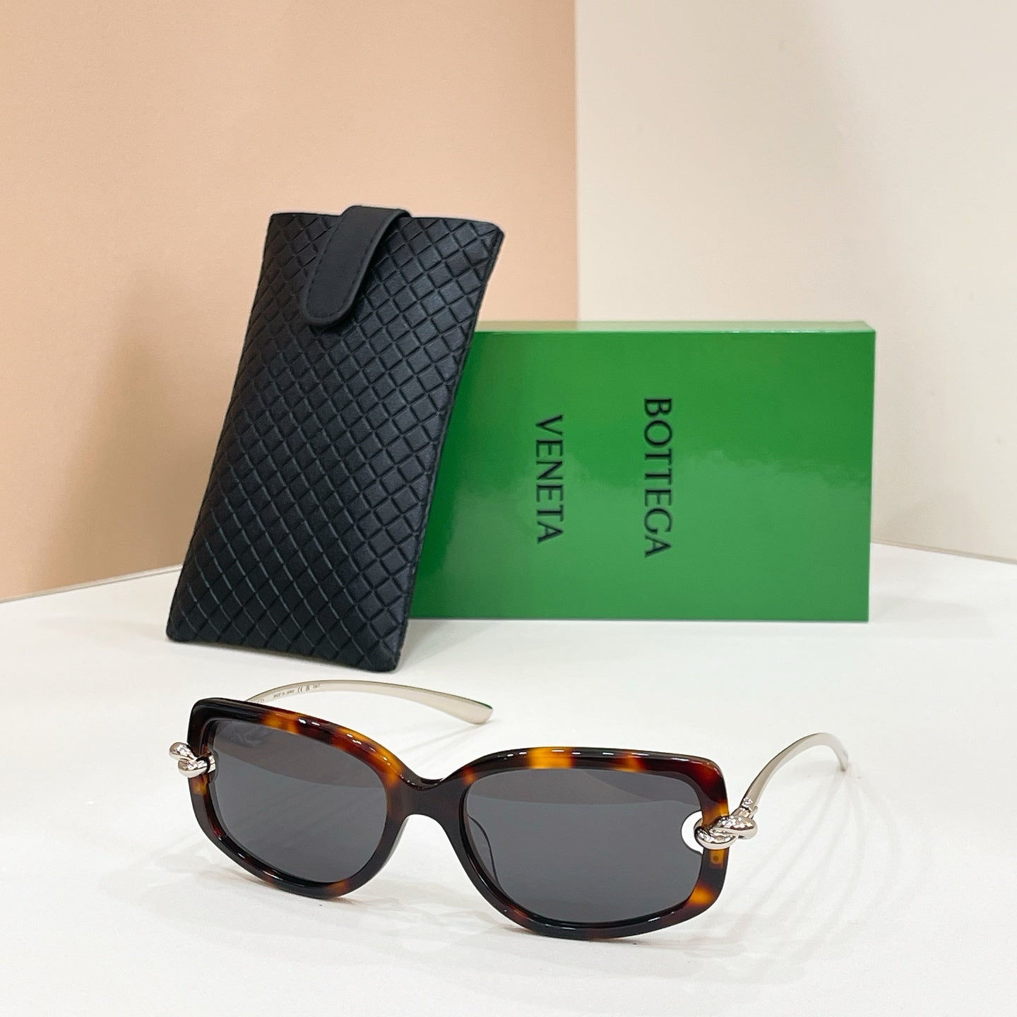 Tortoiseshell sunglasses with dark lenses and metal arms, paired with a black case