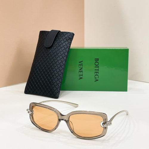 Light tan sunglasses with amber lenses and metal arms, with a black patterned case