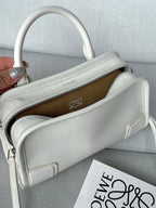 White leather handbag with zip opening and brown fabric interior