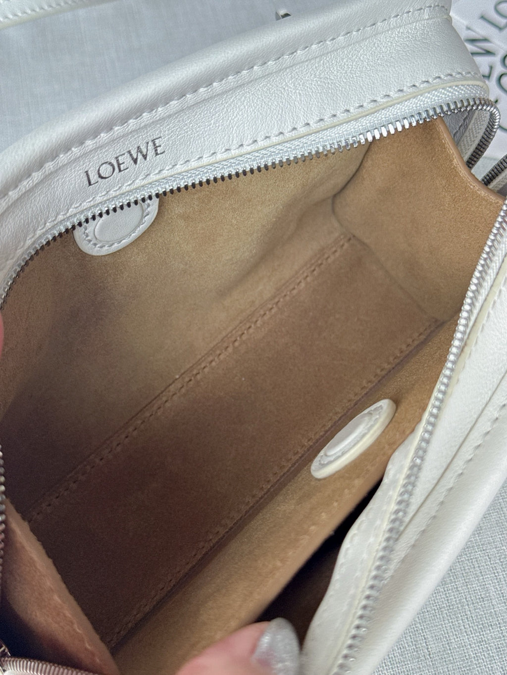 White leather handbag interior with brown lining and open zip compartment