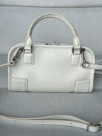 White leather handbag with top handles, front panels, and detachable shoulder strap