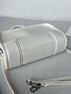 White leather handbag side view with stitched trim and silver zipper hardware