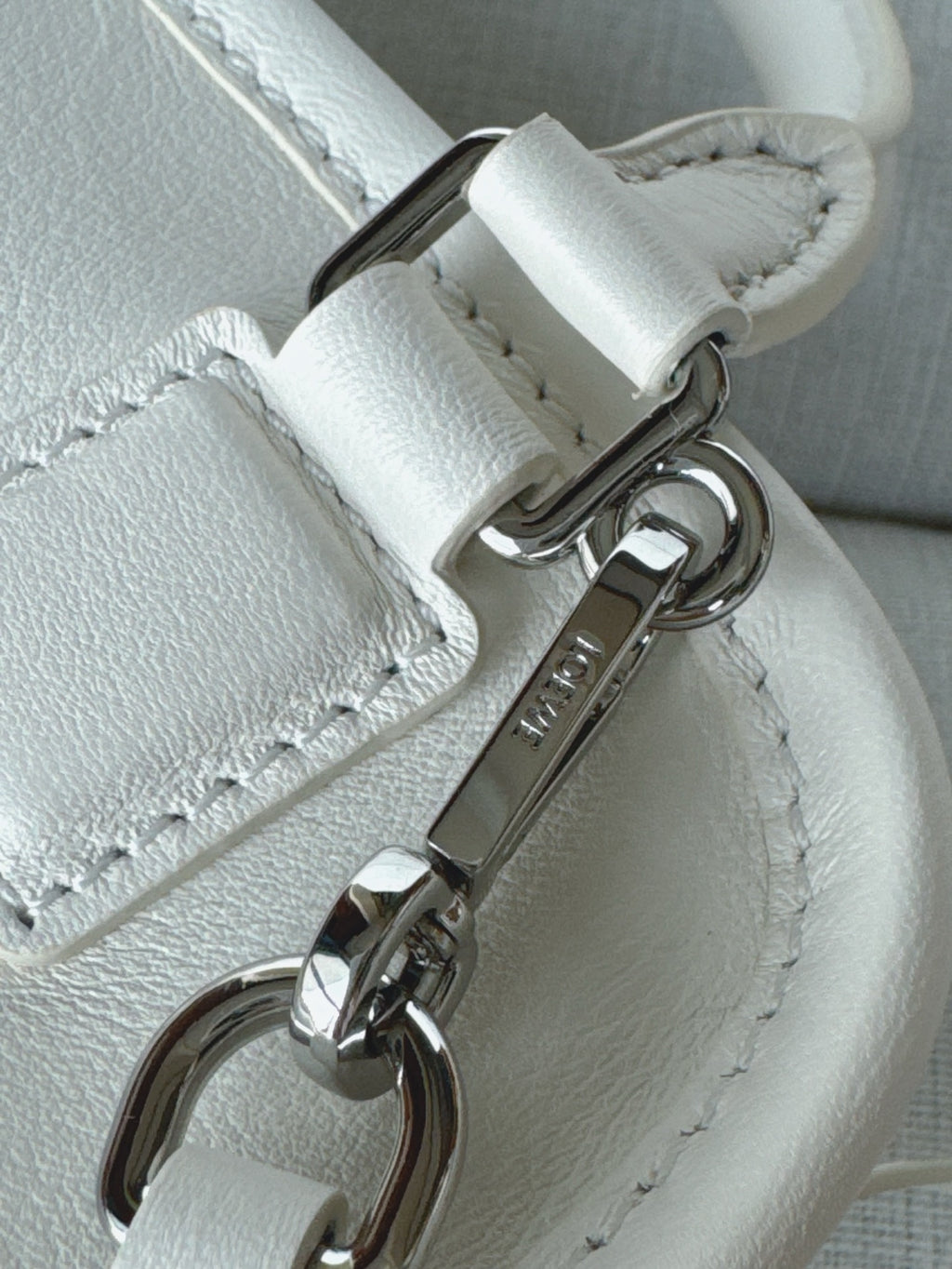 White leather handbag key ring clasp with metal hardware and stitched strap