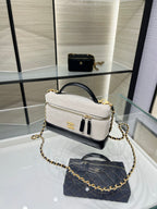 Chanel bag in light gray with gold chain strap, black trim and top zipper