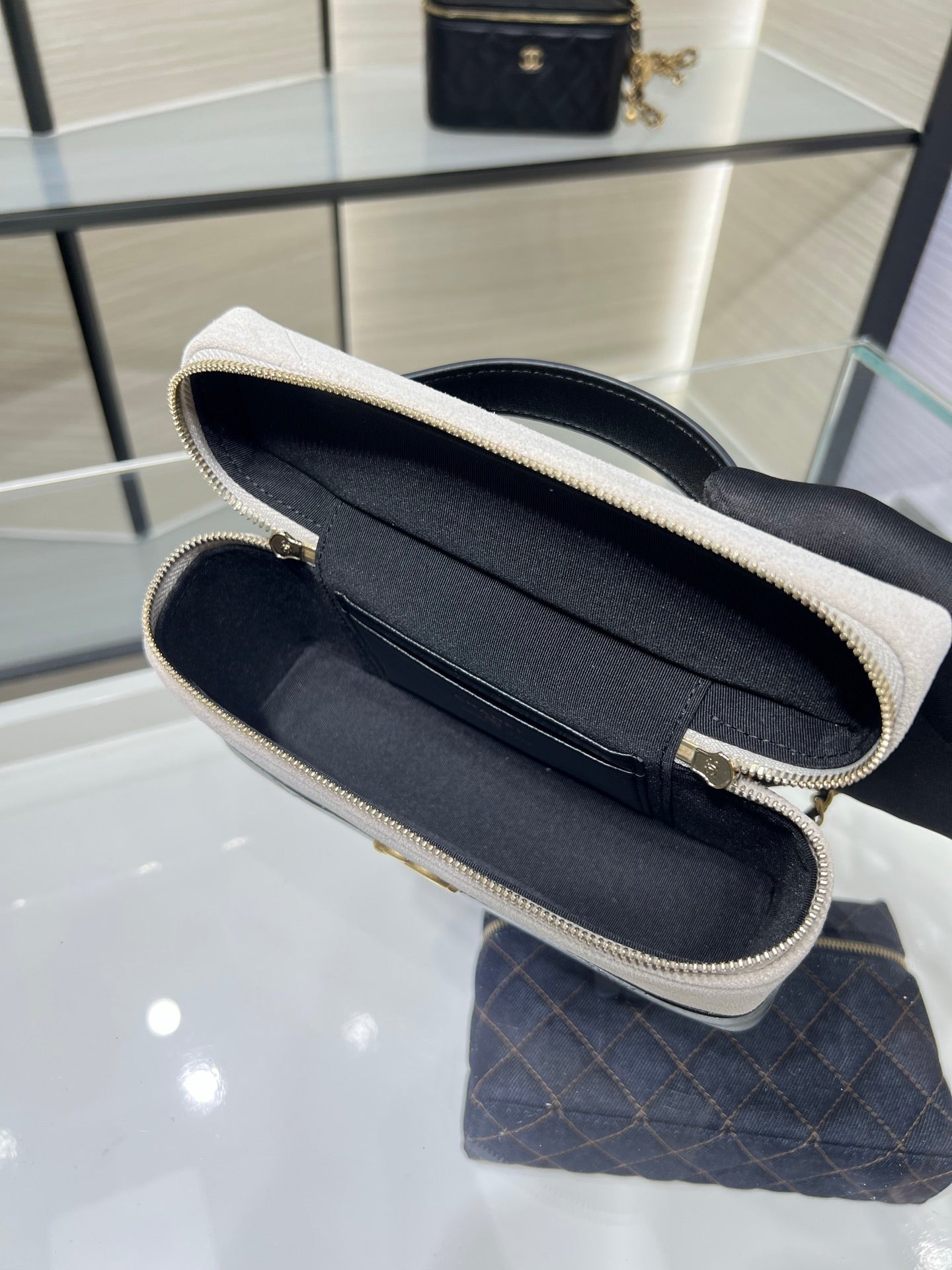 Chanel bag open to dark interior with stitched trim along zipper opening