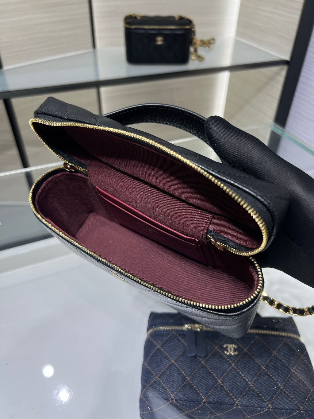 Chanel mini handbag open view, black exterior and burgundy interior, zip top