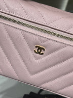 Pink quilted bag front panel with gold logo charm and zip pull