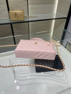 Pink rectangular quilted clutch with gold chain strap and front twist clasp