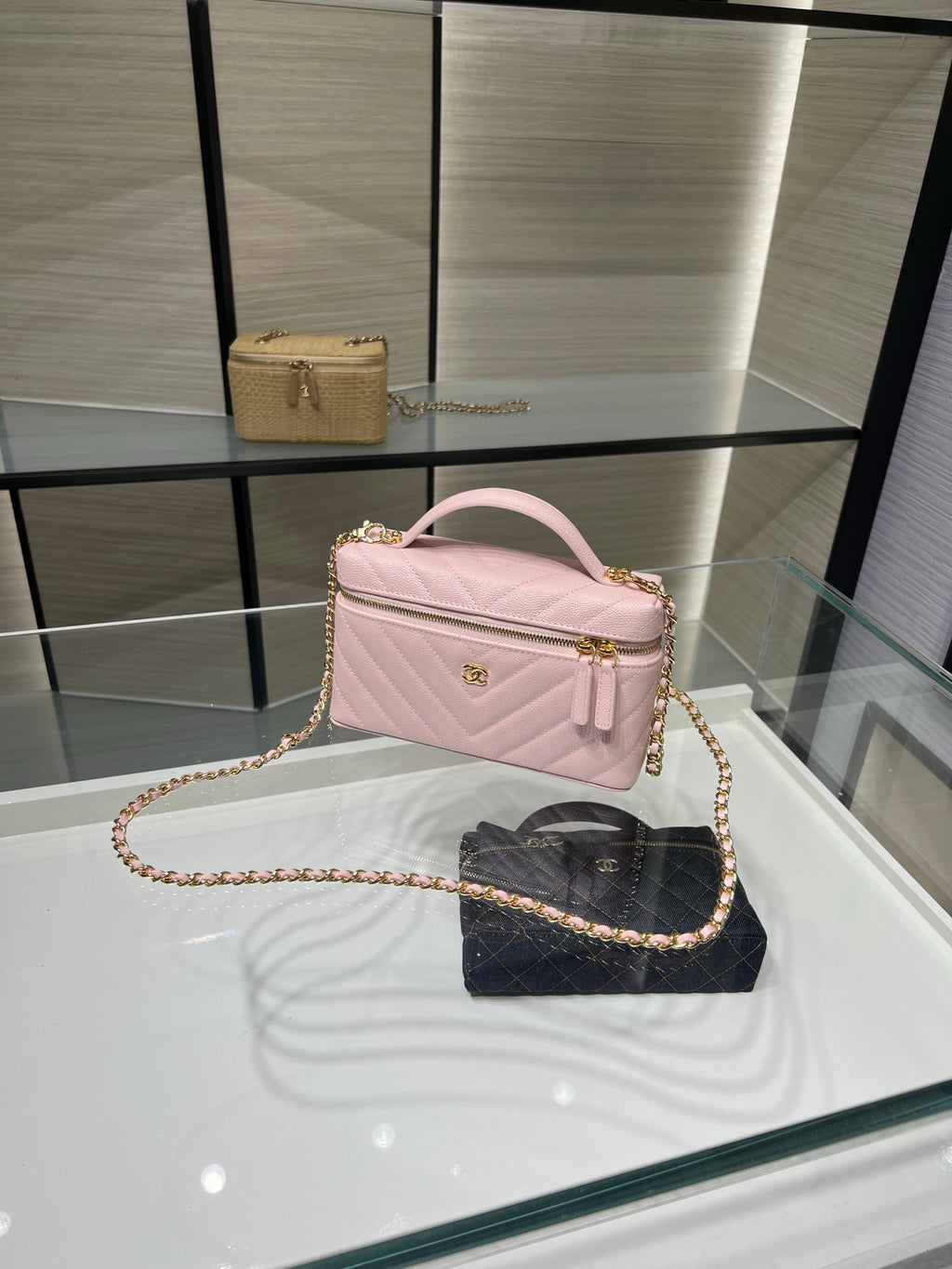 Pink quilted shoulder bag with curved handle, gold chain strap, and zip top