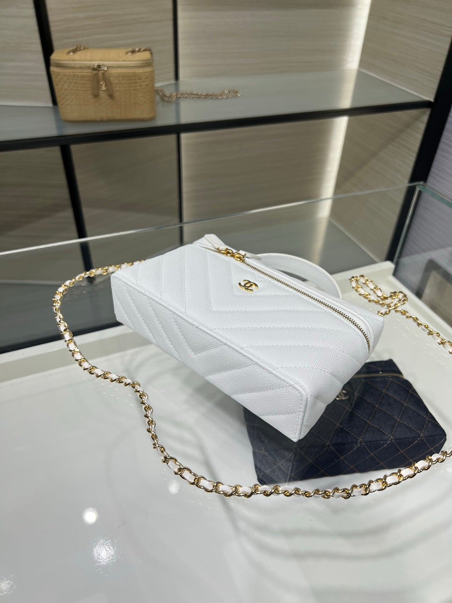 Chanel quilted white bag with chain strap and gold zipper, angled side view
